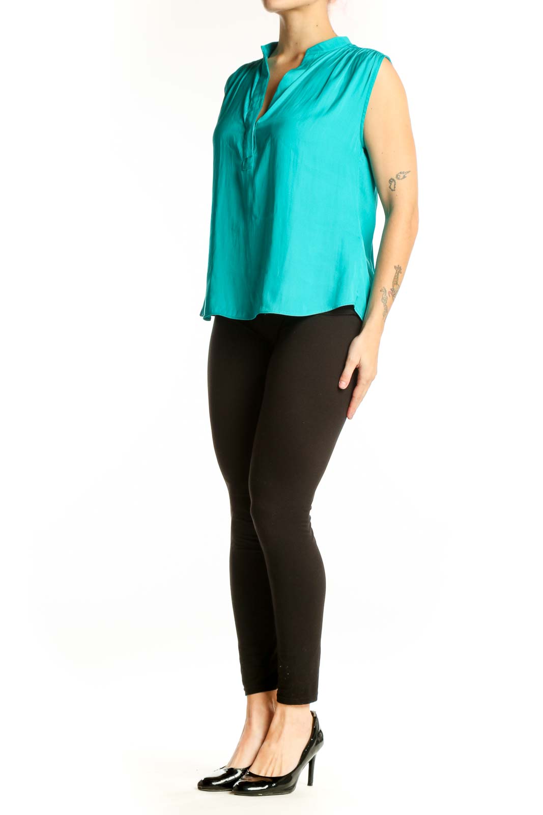Turquoise sleeveless V-neck blouse with pleated shoulders, front view on model