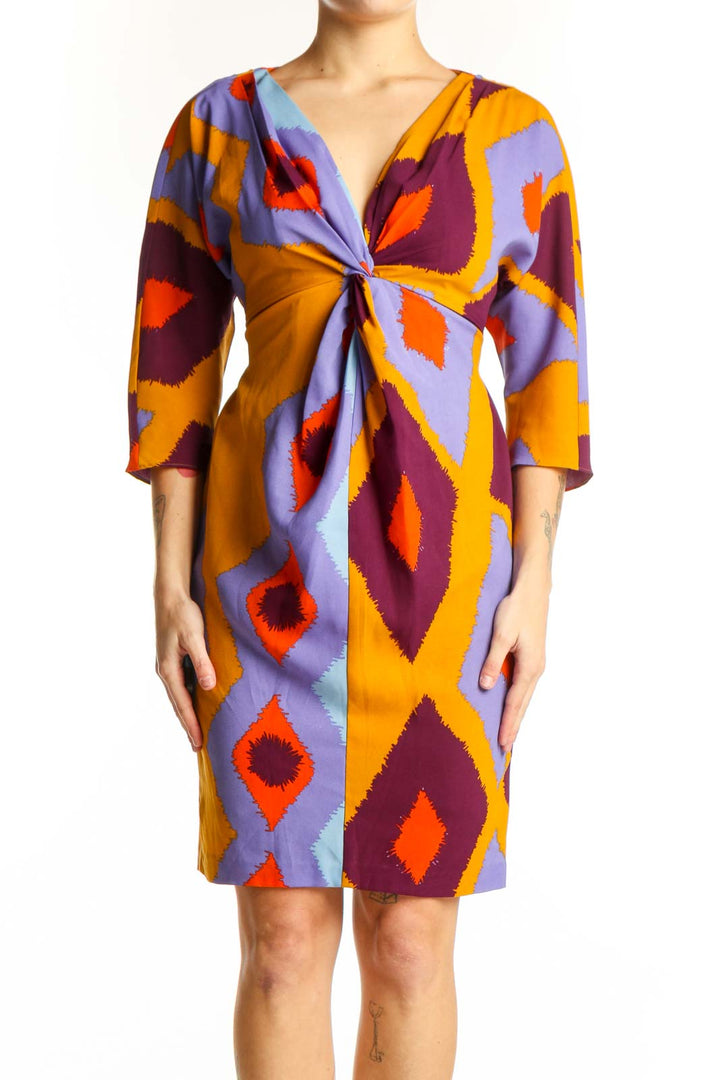 Front view of multicolor geometric print wrap dress with purple, orange, burgundy and gold diamond pattern by Vince Camuto