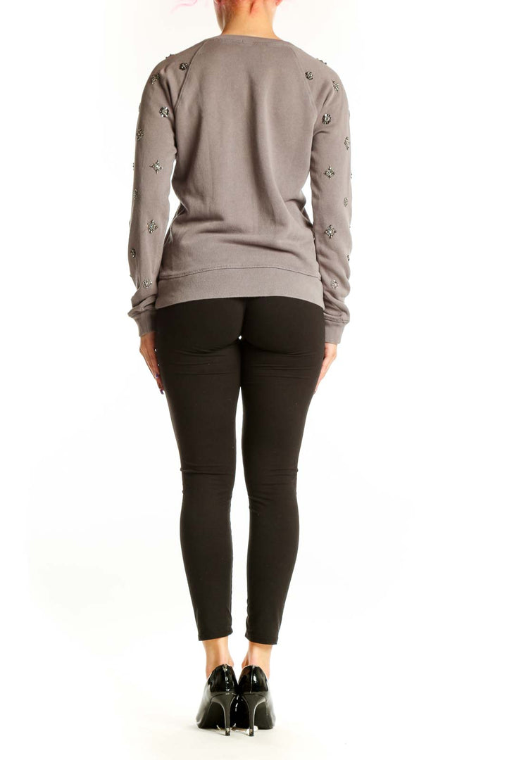 Back view of taupe J.Crew embellished sweatshirt showing metallic starburst details across shoulders and back