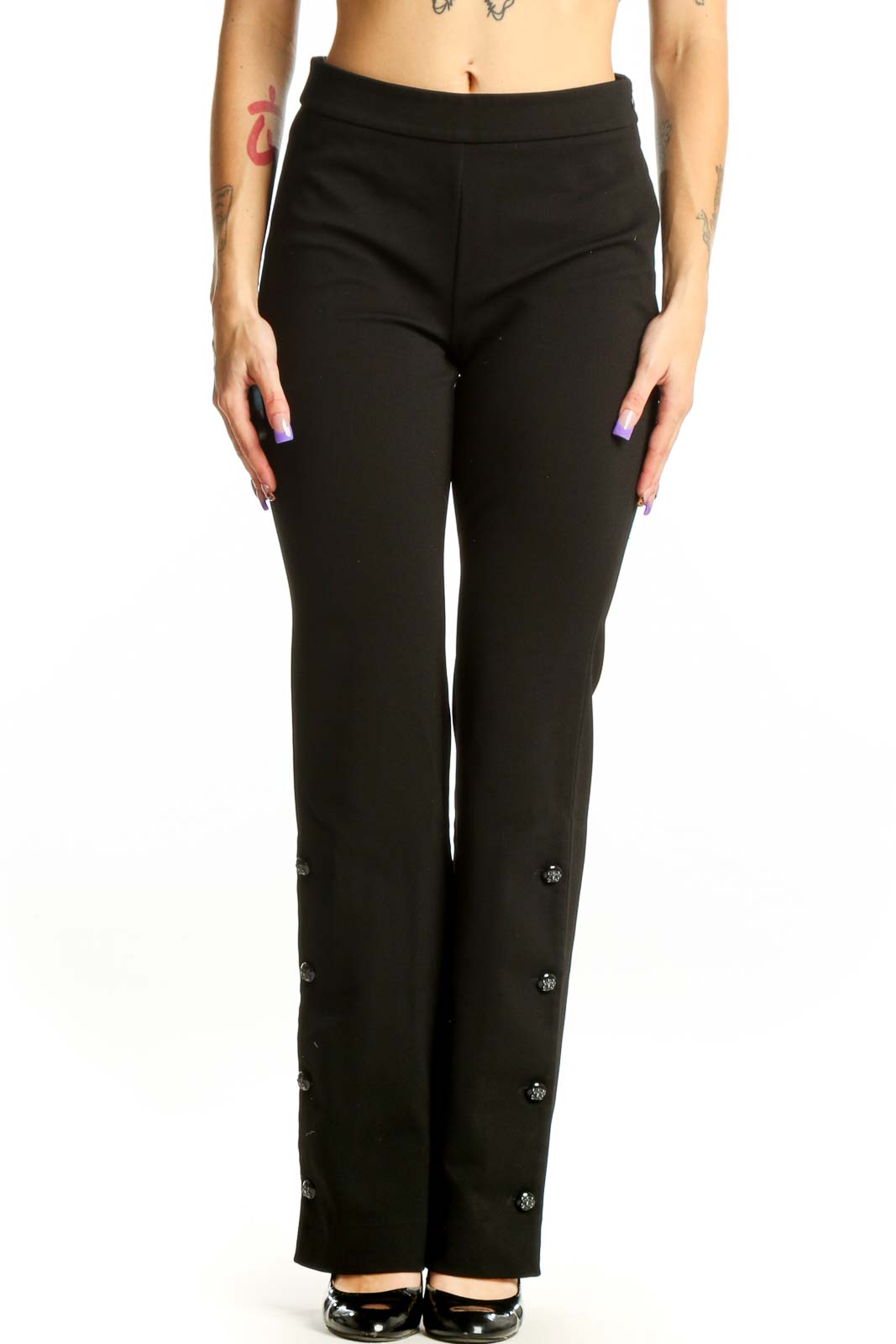 Black flare pants with decorative button details on outer seams, high-waisted design, front view