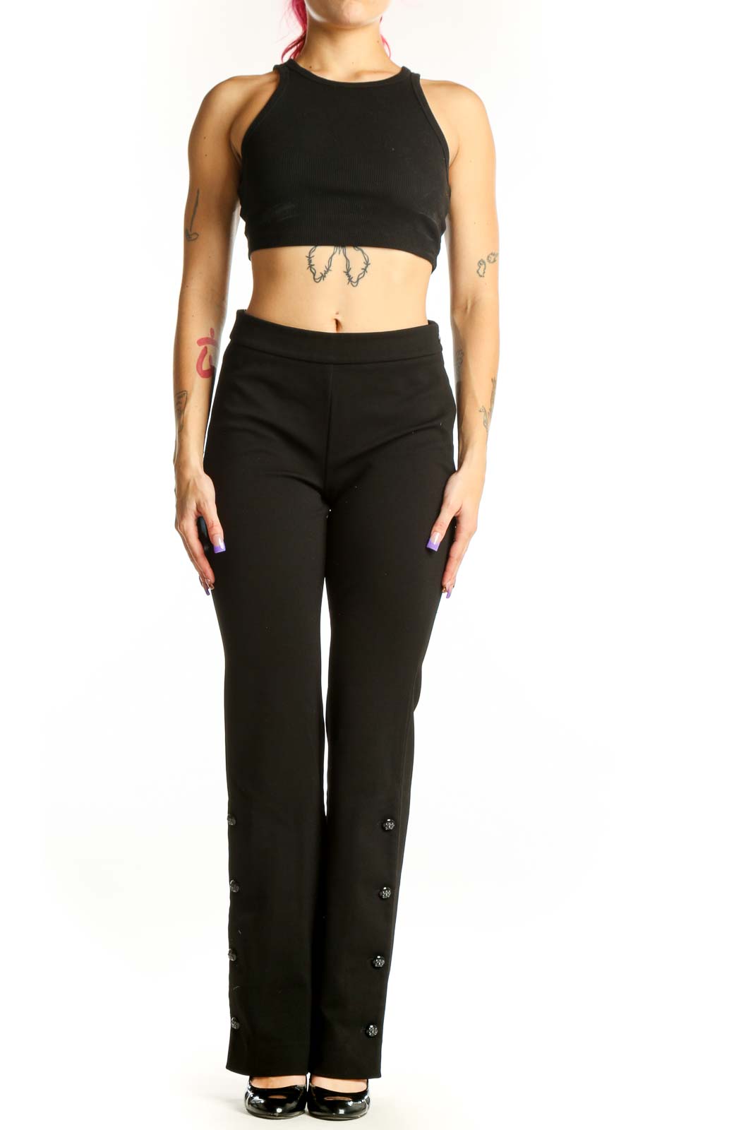 Black flare pants with decorative button details on outer seams, high-waisted design, front view