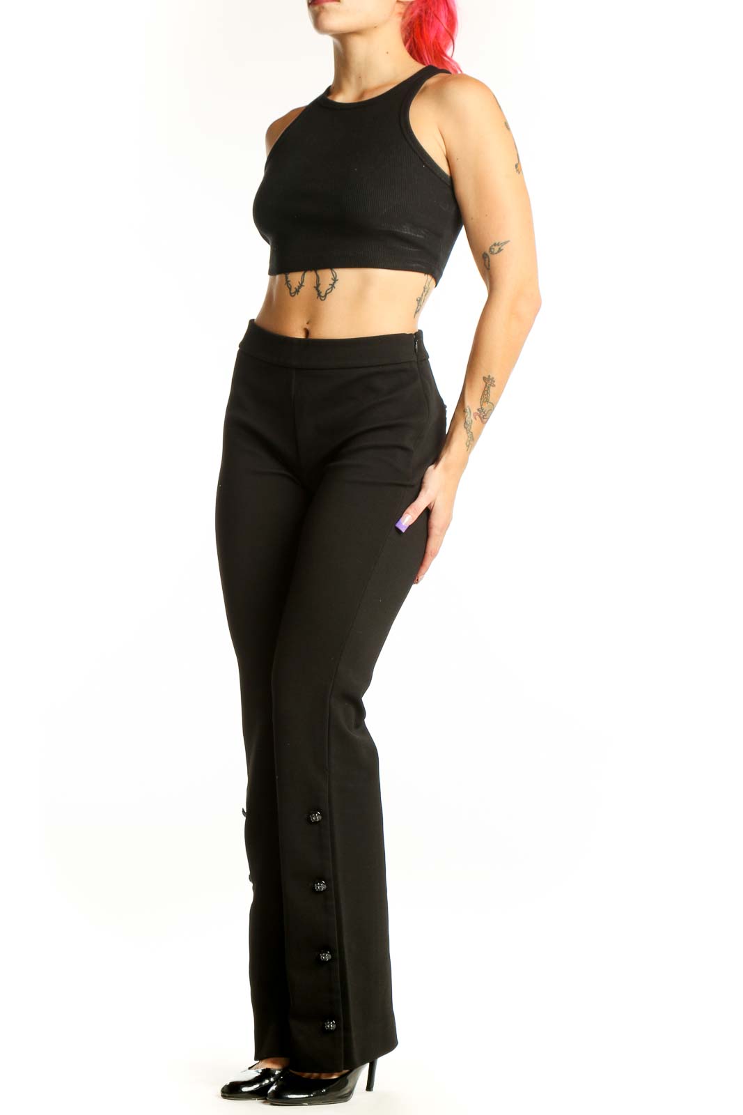 Black flare pants with decorative button details on outer seams, high-waisted design, front view