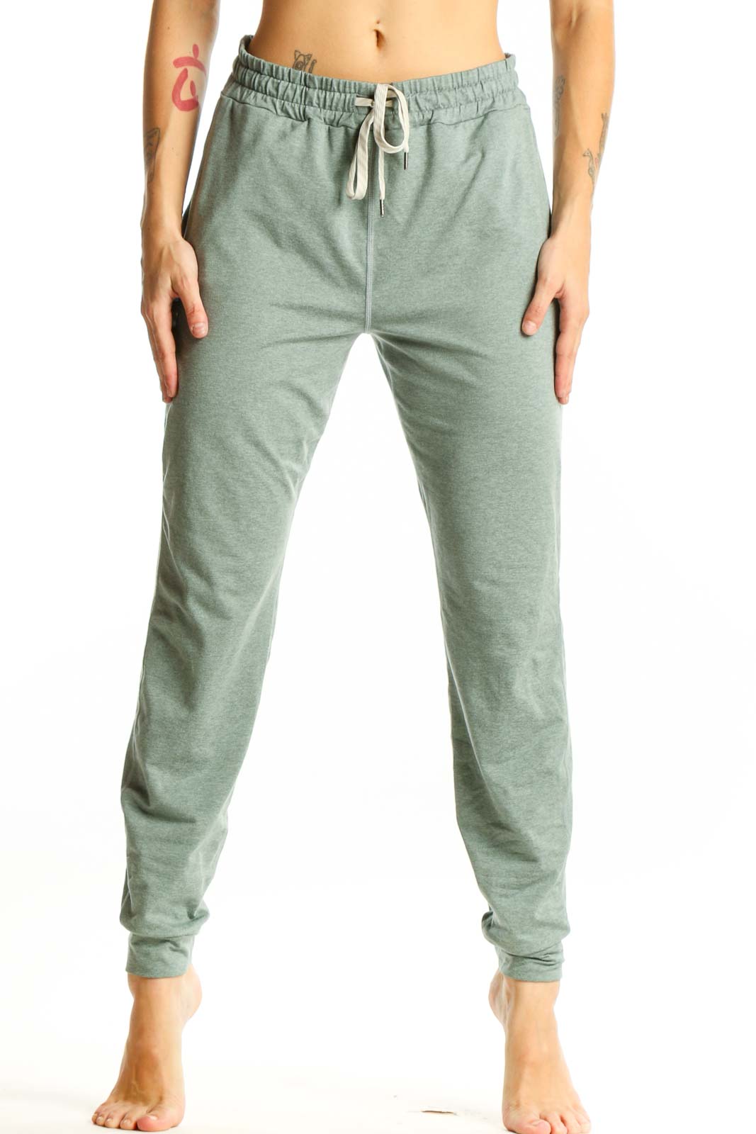 Front view of sage green Vuori jogger pants with drawstring waist