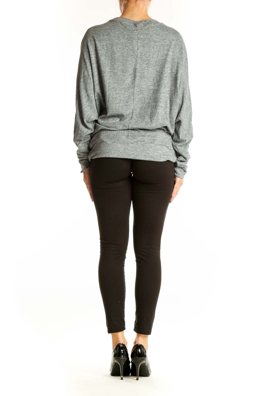 Side view of model wearing gray oversized knit sweater with black pants