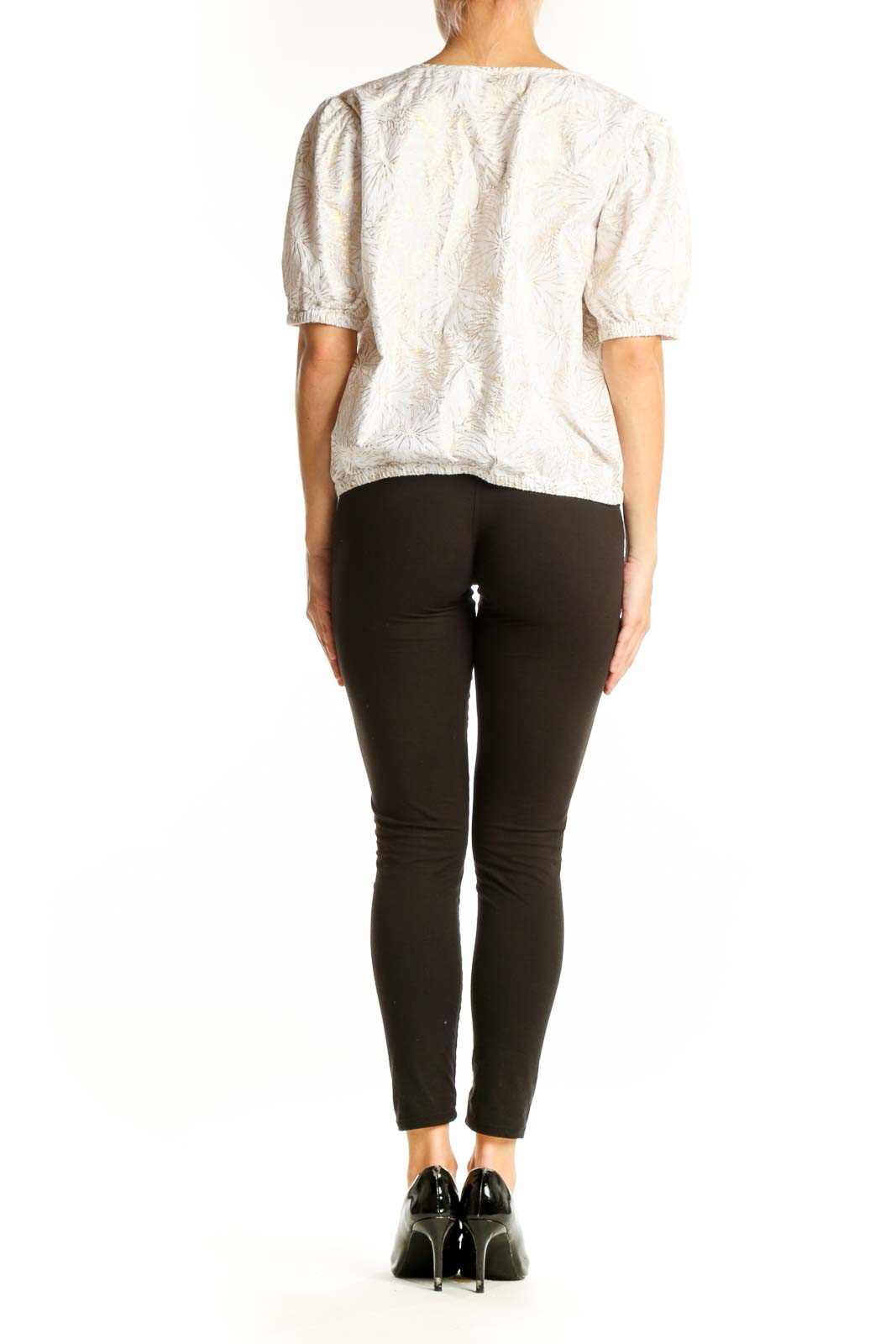 Side view of Michael Kors white embroidered blouse with black pants