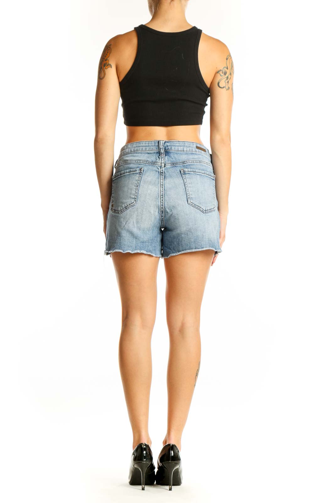 Side view of model wearing KUT from the Kloth light blue denim shorts with black crop top