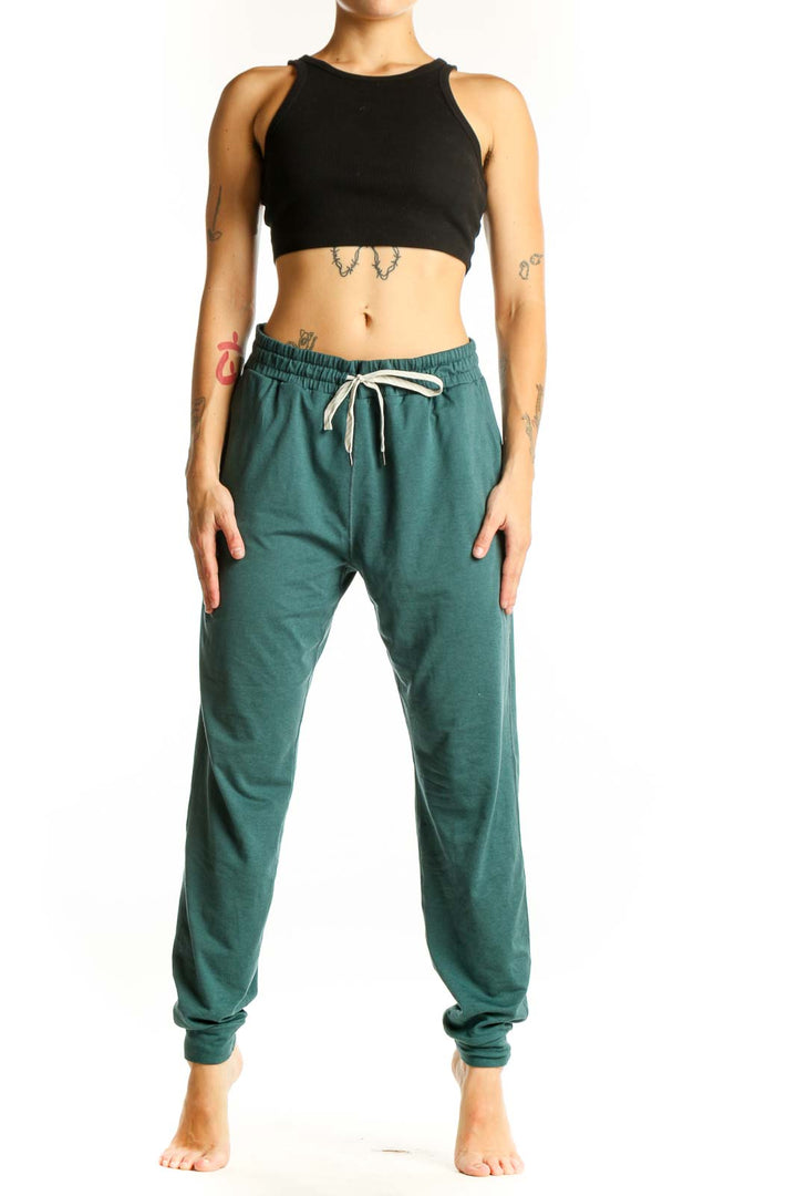 Front view of green Vuori jogger pants with drawstring waist