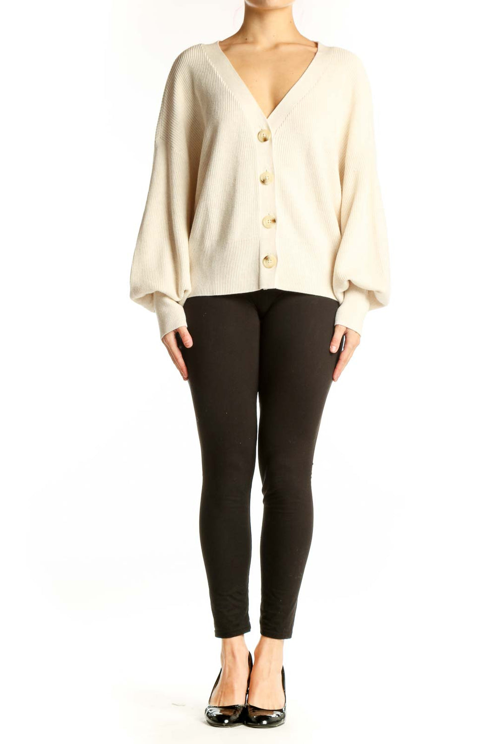 Cream ribbed button-front cardigan with puffed sleeves and gold buttons, worn with black pants