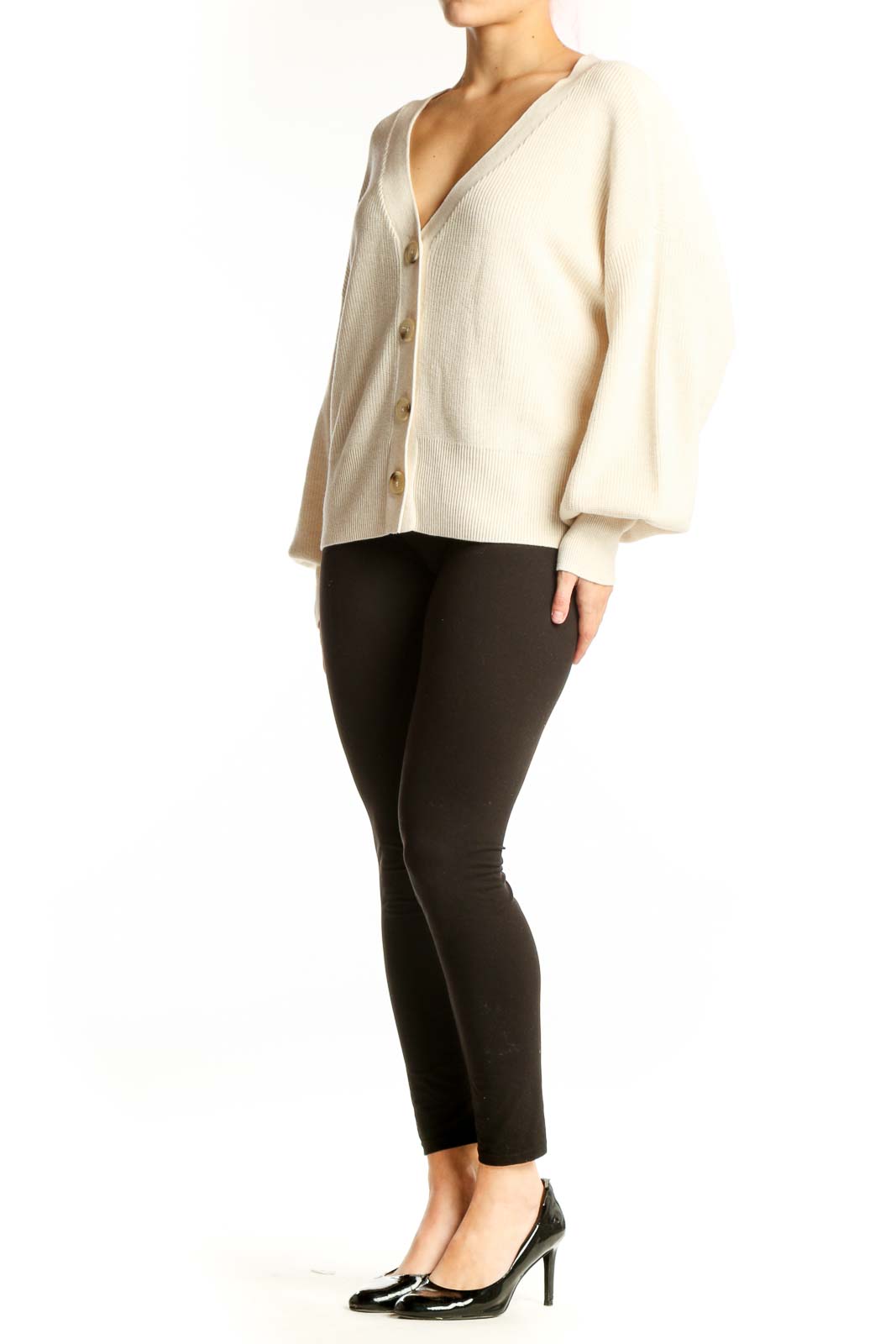 Cream ribbed button-front cardigan with puffed sleeves and gold buttons, worn with black pants