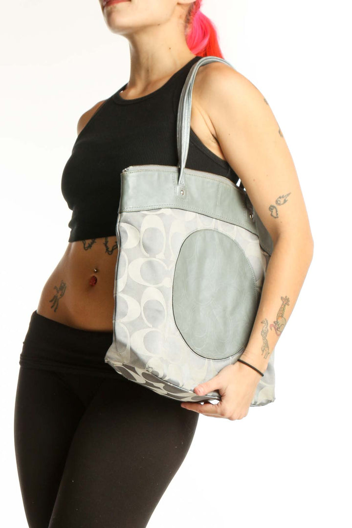 Cream Coach Signature Monogram Tote Bag with sage green leather handles and circular medallion detail, front view