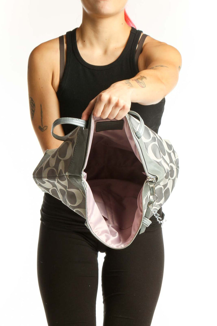 Coach Signature Tote Bag worn on shoulder, showing back view with monogram pattern and leather trim details