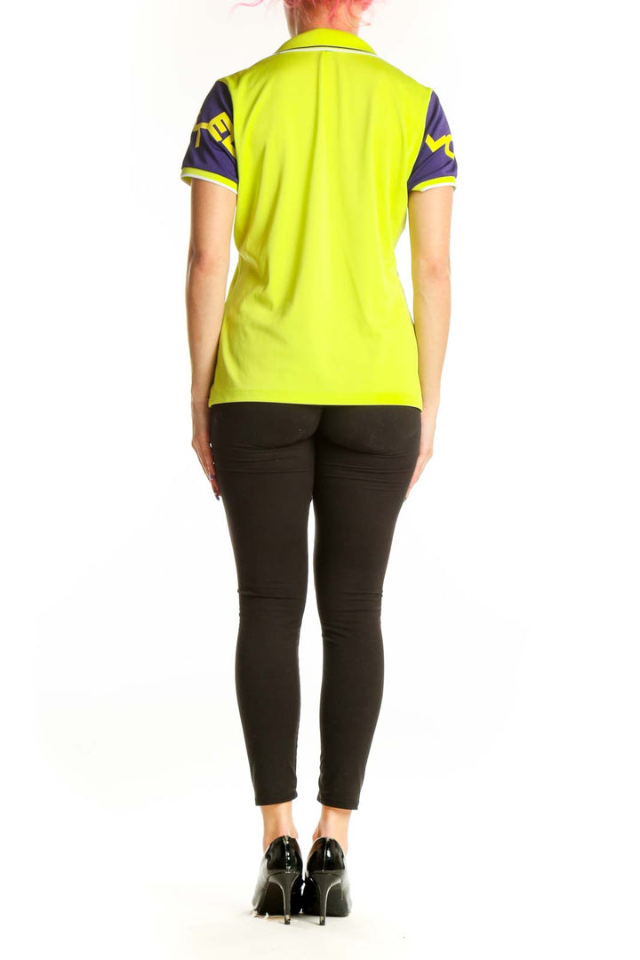 Back view of neon yellow polo shirt with purple sleeves and graphic design by Louis Castel
