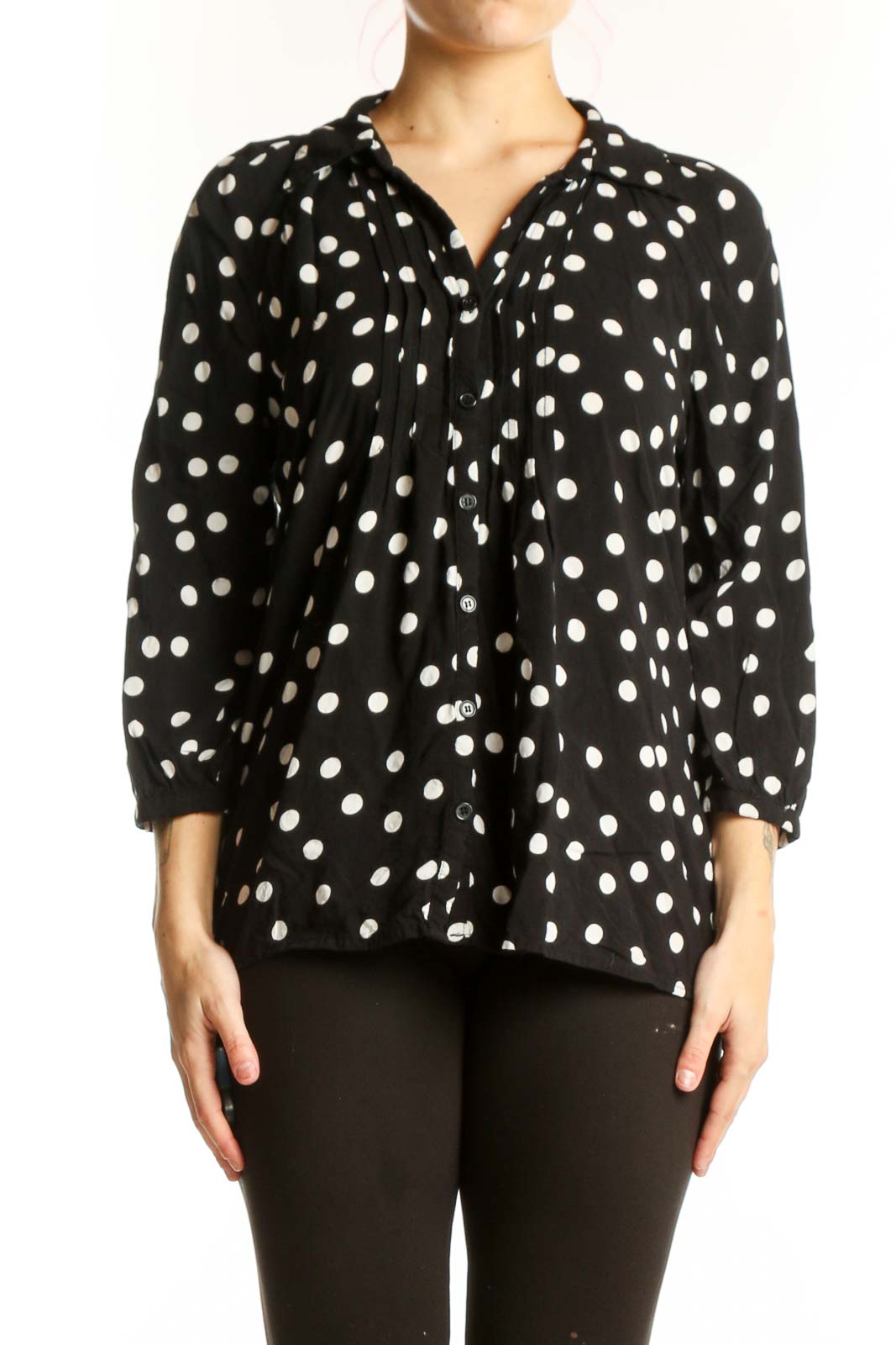 Black viscose top with white polka dots and button-up front, worn with black pants