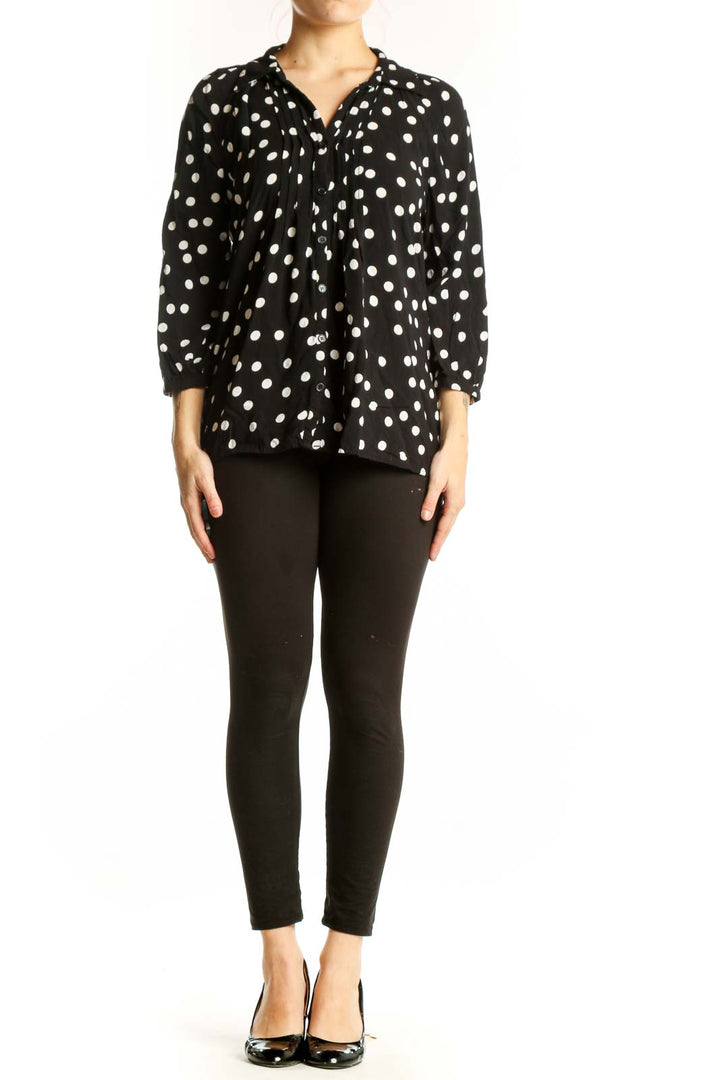 Black viscose top with white polka dots and button-up front, worn with black pants