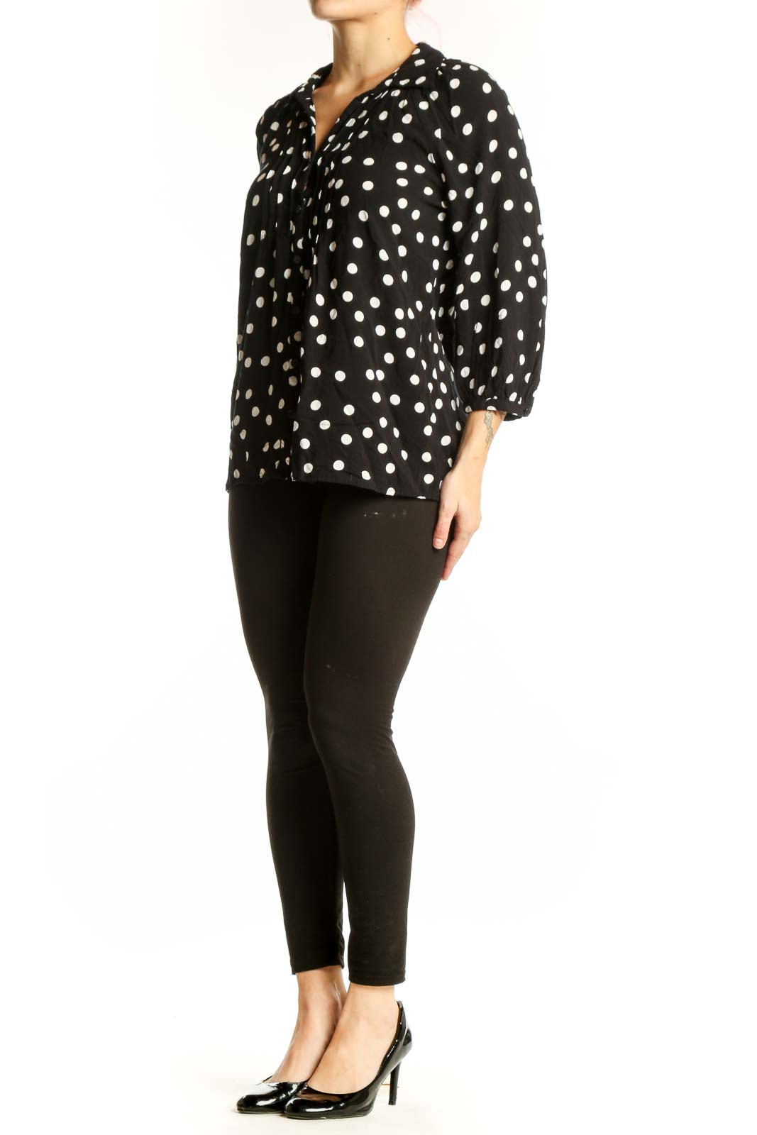 Black viscose top with white polka dots and button-up front, worn with black pants