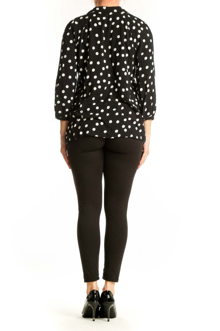 Back view of black polka dot viscose top showing relaxed fit and three-quarter sleeves