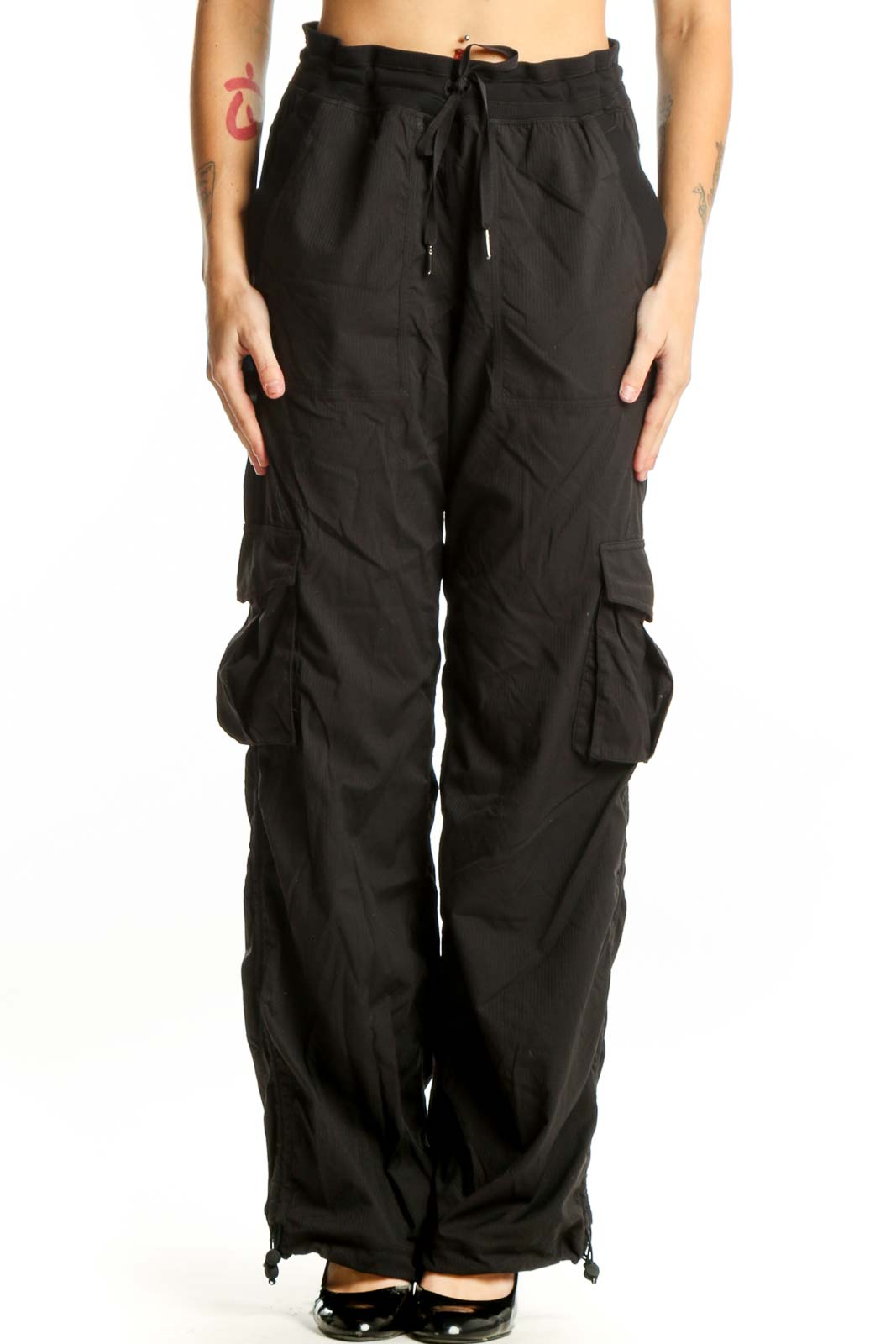 Black cargo pants with side pockets and drawstring waistband, front view