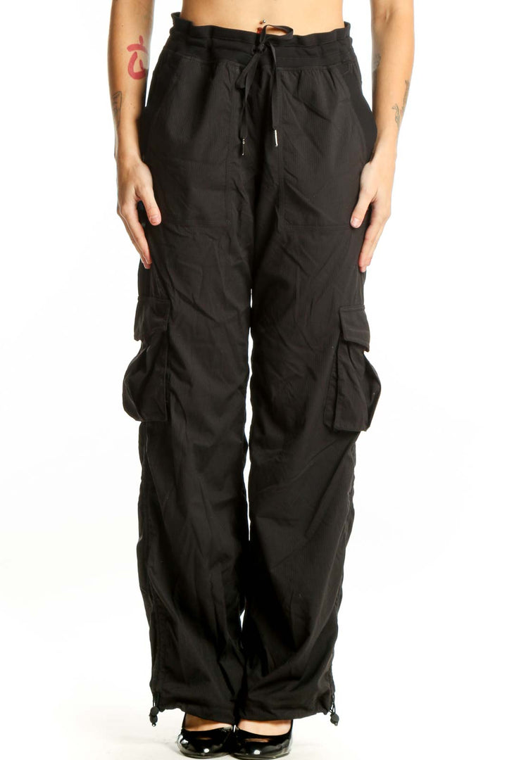 Black cargo pants with side pockets and drawstring waistband, front view