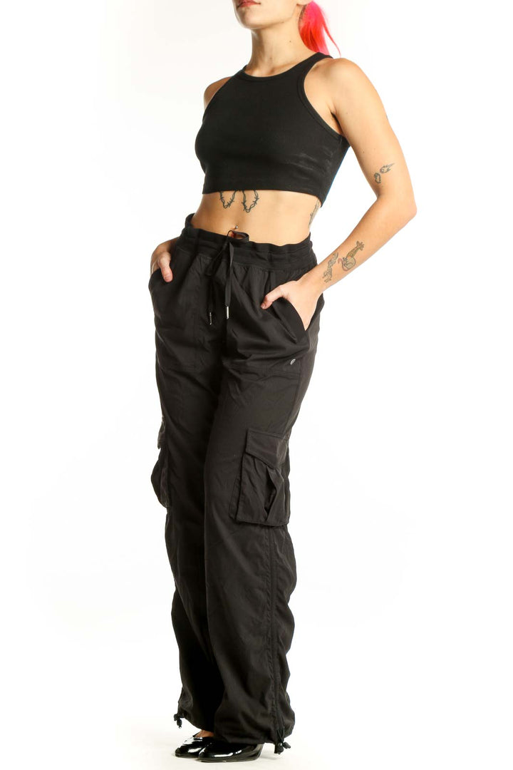 Black cargo pants with side pockets and drawstring waistband, front view