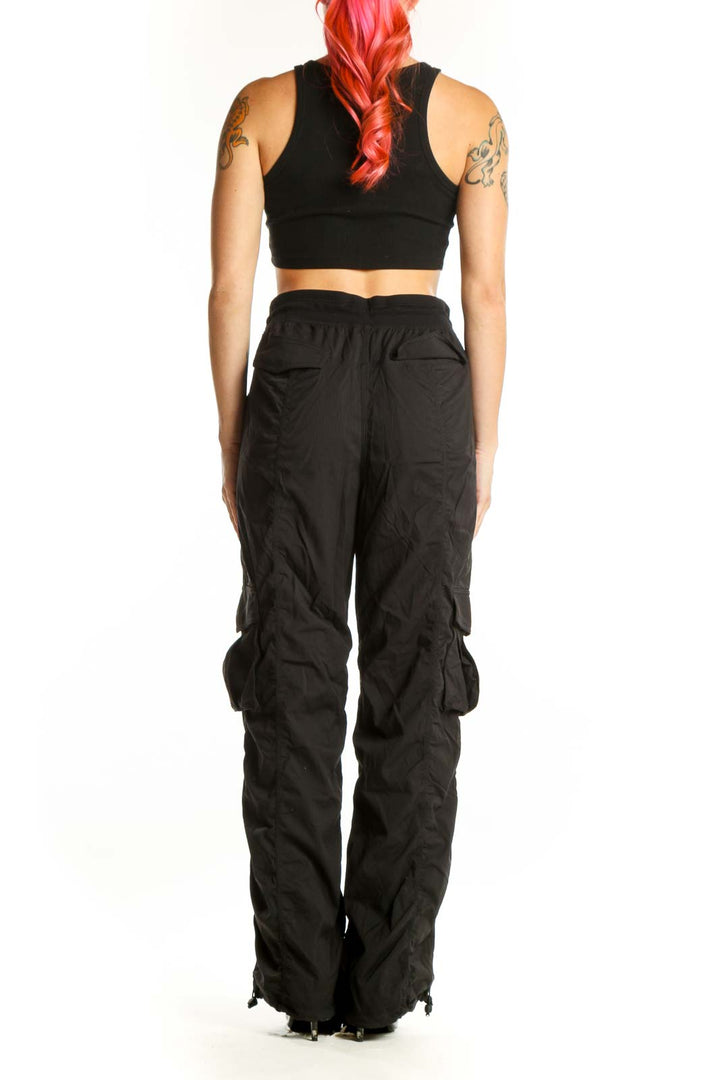 Black cargo pants with functional side pockets, back view showing relaxed fit