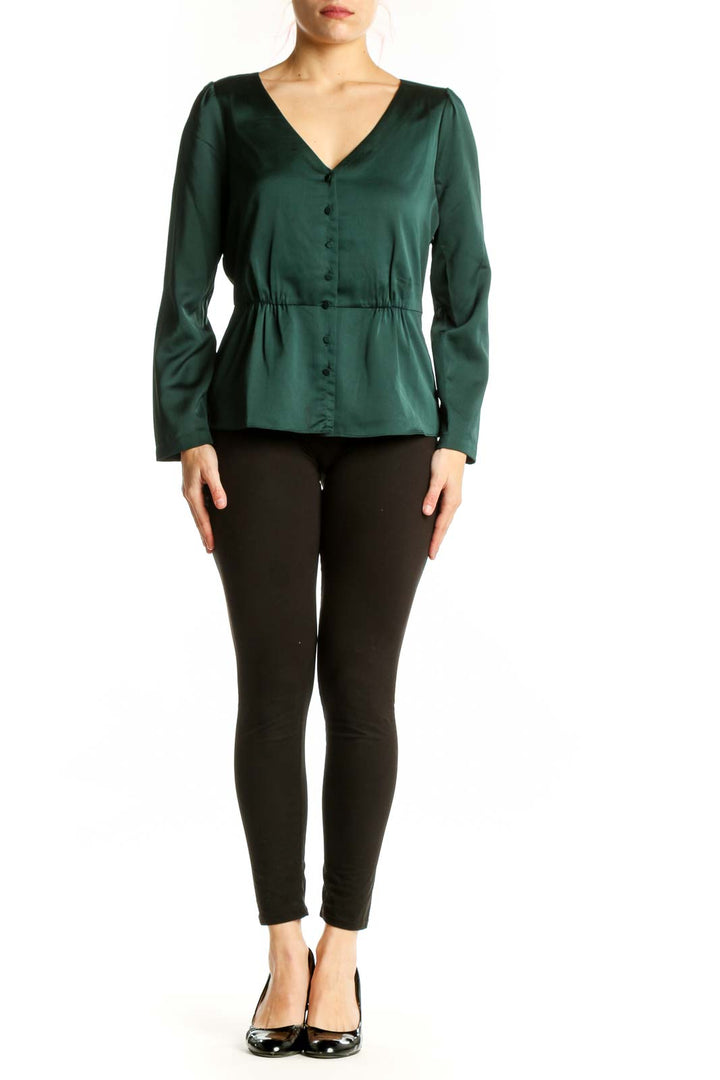 J.Crew green peplum top with V-neckline and button-front closure, worn with black pants
