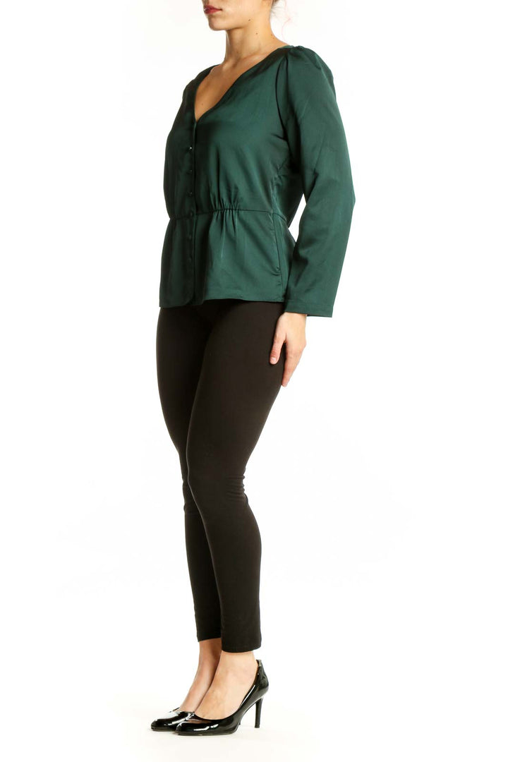 J.Crew green peplum top with V-neckline and button-front closure, worn with black pants