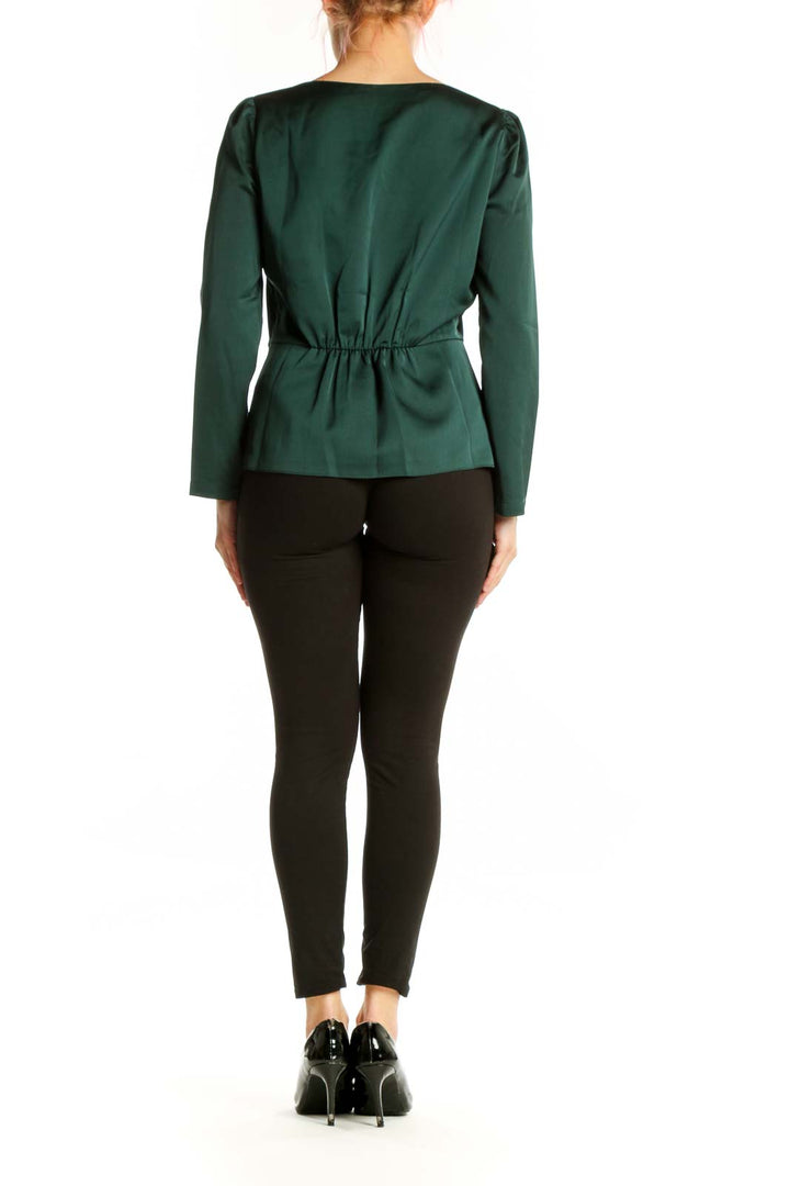 Back view of J.Crew green peplum blouse showing cinched waist and long sleeves