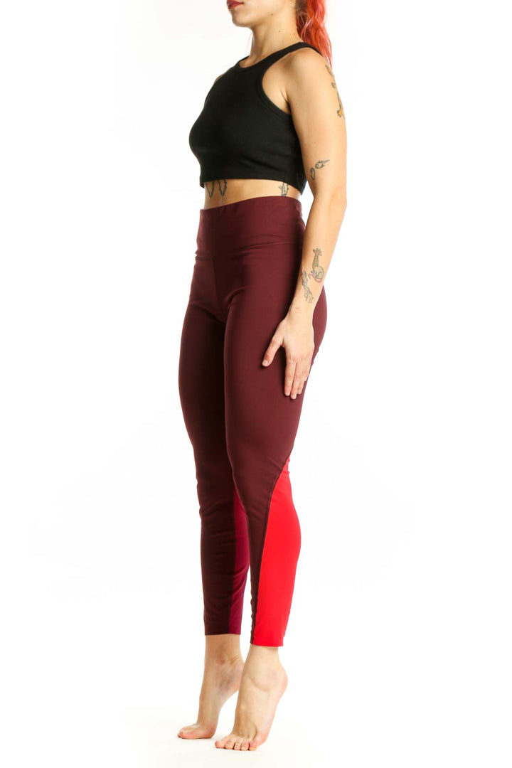 Burgundy and red colorblock cropped leggings front view, high-waisted fit with side stripe detail