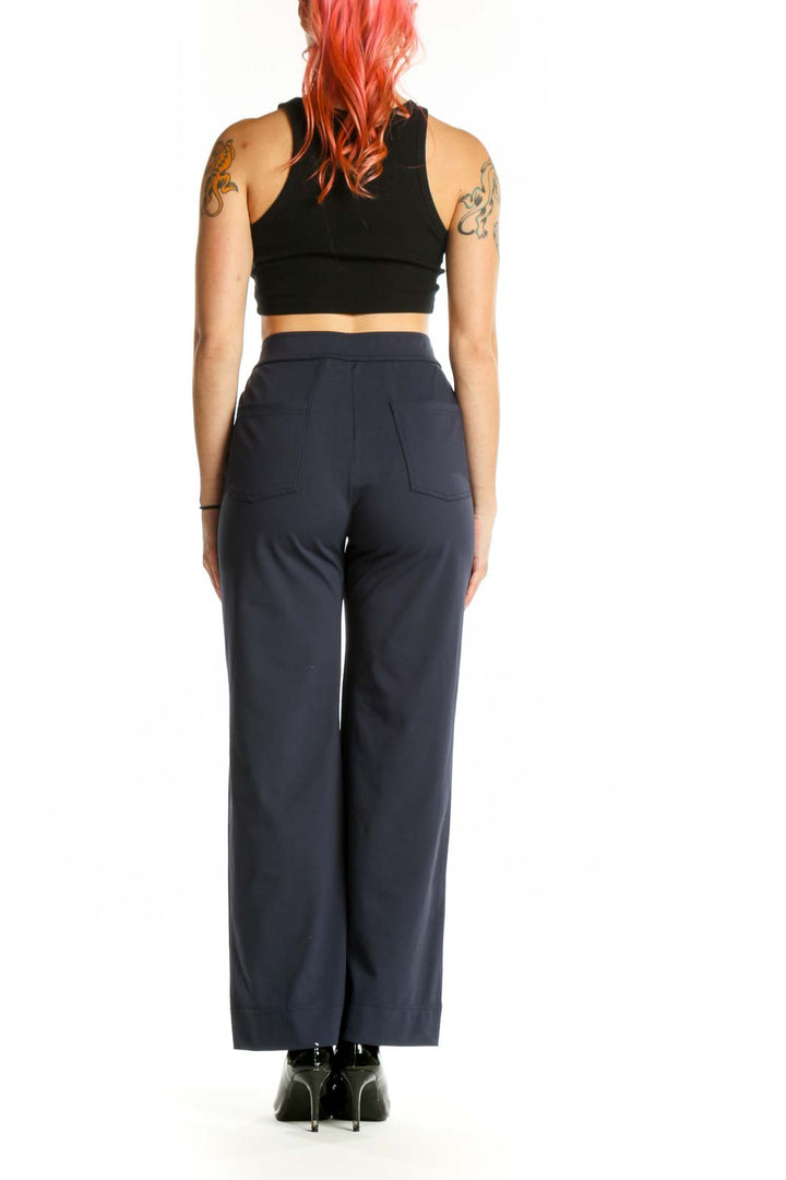 Navy high-waisted button-front pants, back view showing tailored fit and silhouette