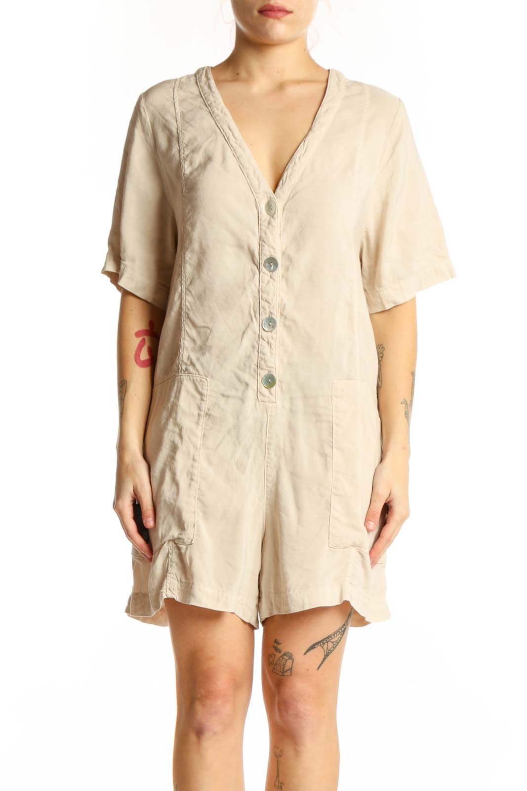 Cream button-front short sleeve romper with V-neckline and functional pockets, front view