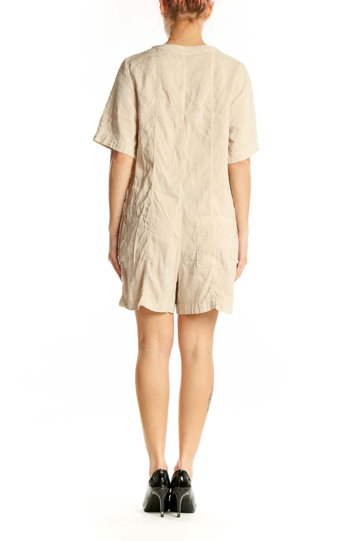 Cream button-front short sleeve romper with V-neckline, back view showing relaxed fit
