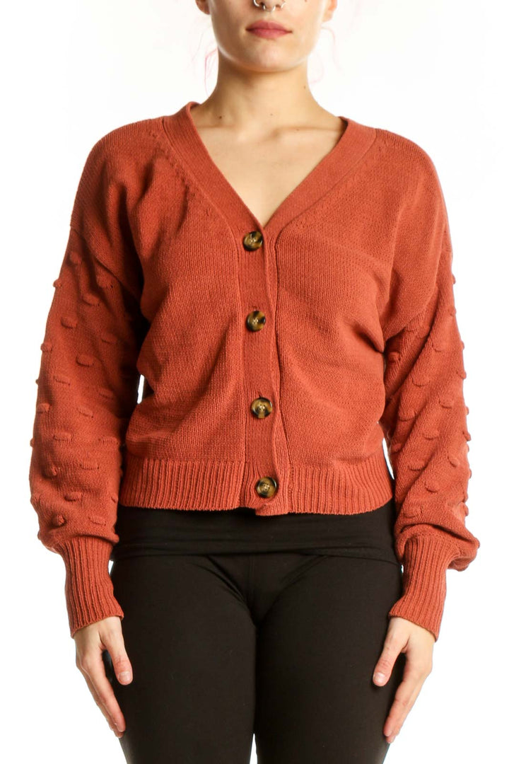 Front view of burnt orange textured button-front cardigan with V-neckline and wooden buttons