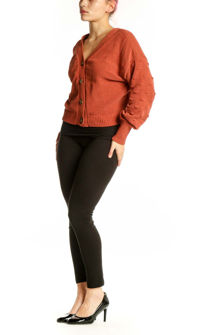 Front view of burnt orange textured button-front cardigan with V-neckline and wooden buttons