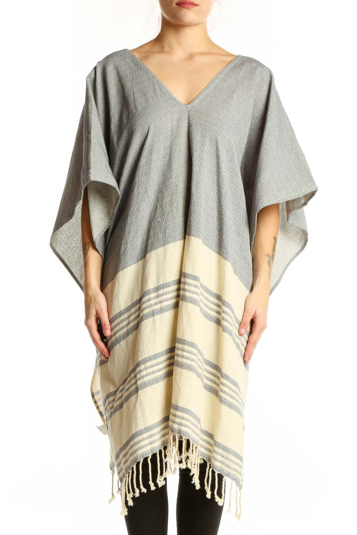 Gray cotton striped poncho knit with cream color-block design and tassel hem, front view