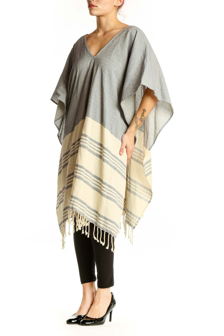 Gray cotton striped poncho knit with cream color-block design and tassel hem, front view