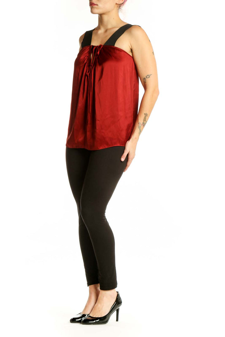 Red sleeveless top with black shoulder straps and drawstring neckline detail, front view
