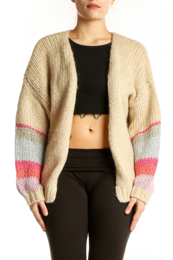 Cream colorblock knit cardigan with pink, gray, and lavender striped sleeves worn over black crop top