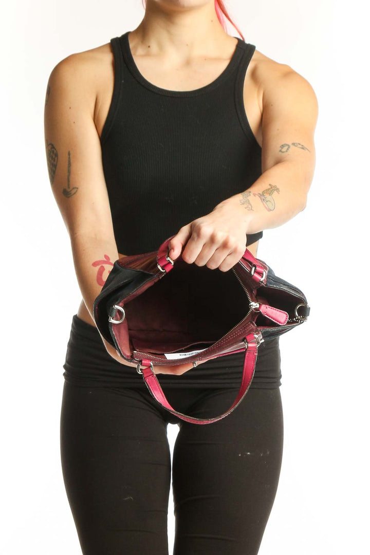 Back view of burgundy and black Coach satchel bag with side zip pocket detail