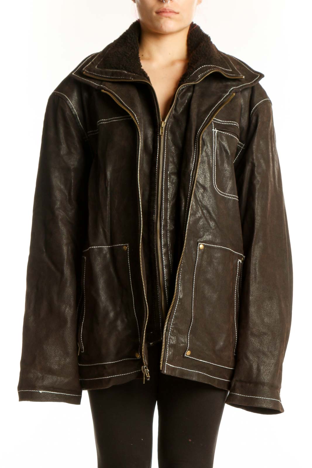 Black genuine leather jacket with cream contrast stitching, oversized fit, and zippered pockets worn by model