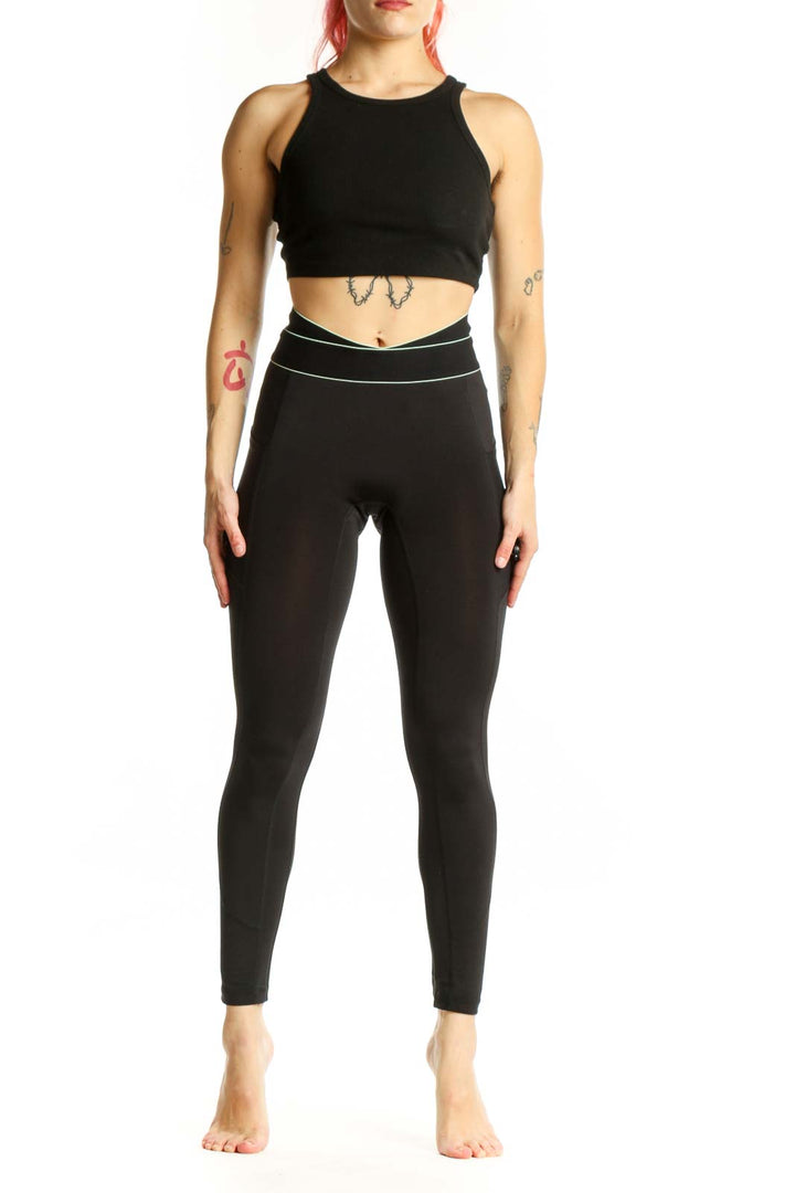 FP Movement black high-waisted nylon leggings with contrast piping, front view on model
