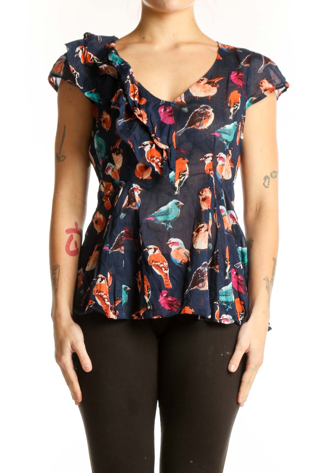 Navy floral cotton top with ruffle cap sleeves and peplum hem, featuring vibrant bird and botanical print