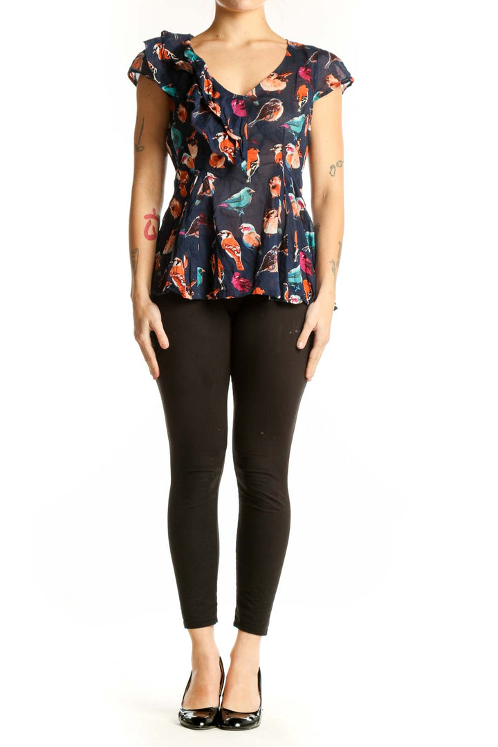 Navy floral cotton top with ruffle cap sleeves and peplum hem, featuring vibrant bird and botanical print