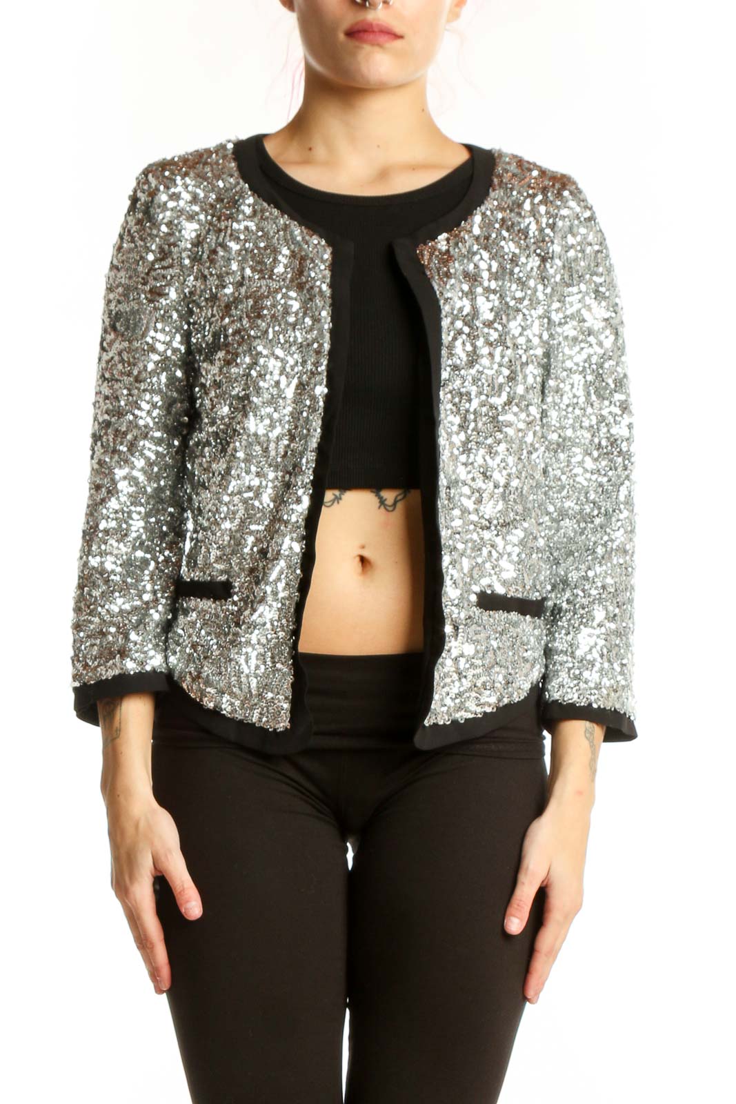 Silver sequin cropped jacket with black trim and open-front design, worn with black crop top and pants
