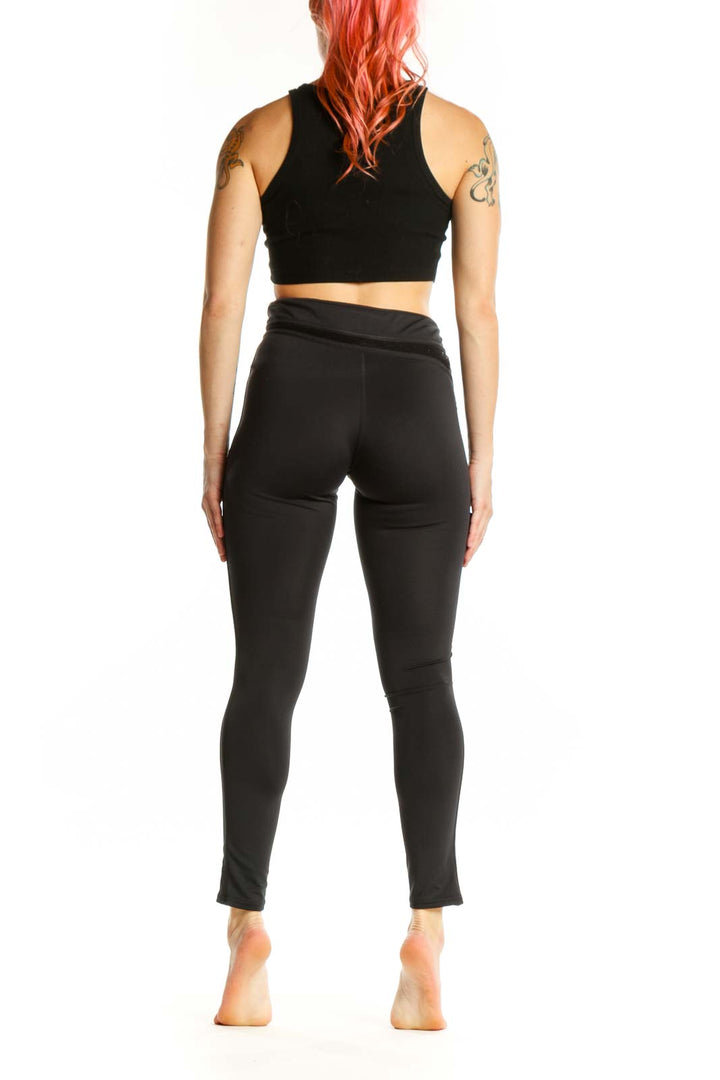 Black wrap waist activewear leggings back view, XS size, displaying form-fitting silhouette and wrap waist detail