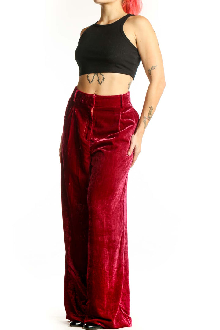 Red velvet wide-leg pants with high waist and pleated front detail, displayed on model