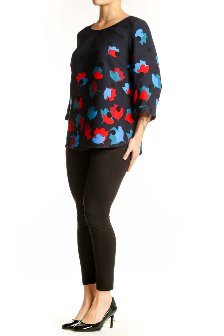 Navy floral print top with red and blue blooms, three-quarter sleeves, crew neckline, front view on model