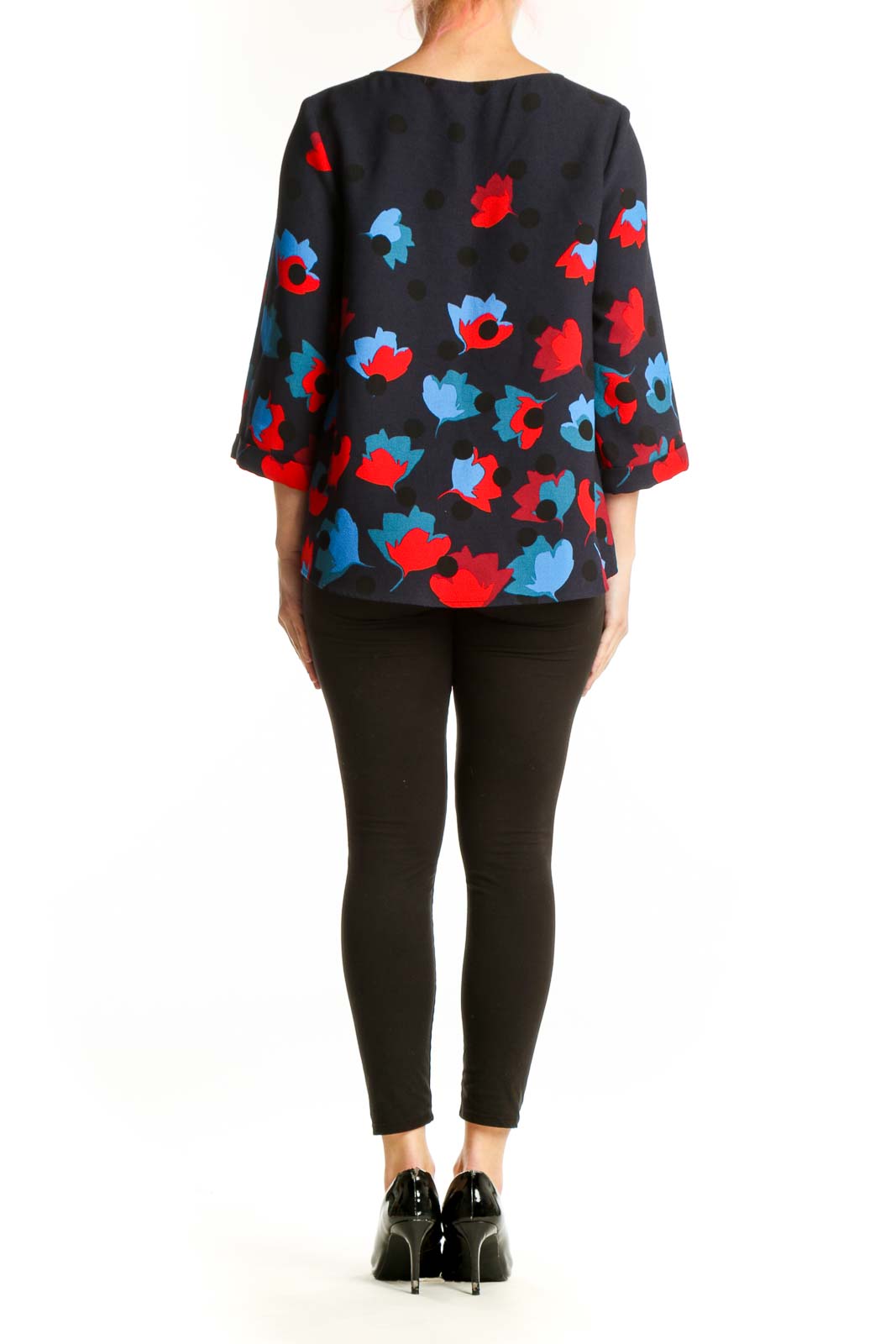 Navy floral print top back view showing vibrant multicolor floral pattern, three-quarter sleeves, paired with black pants