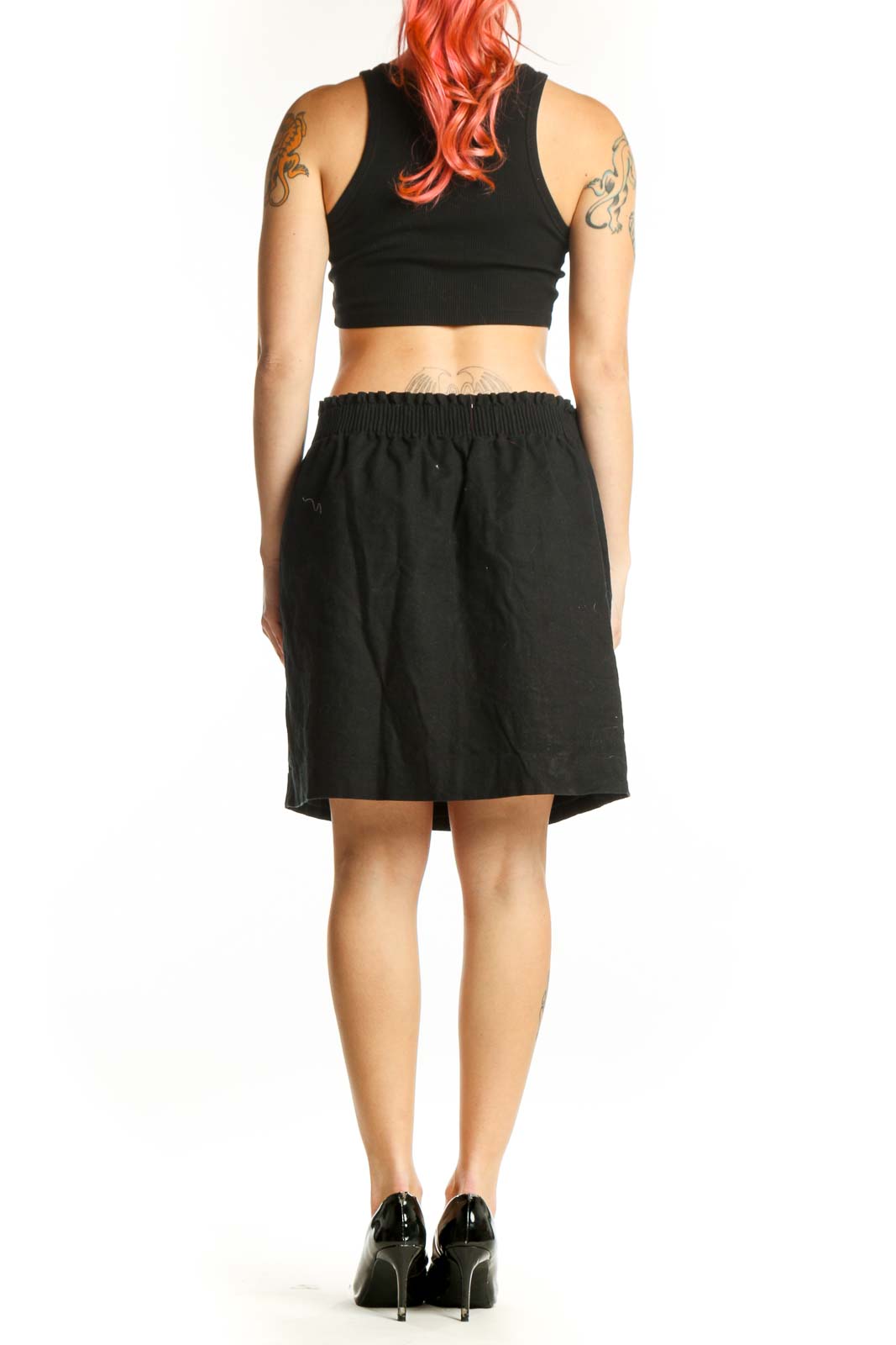 Black cotton-polyester mini skirt with elasticized waistband and side pockets, back view
