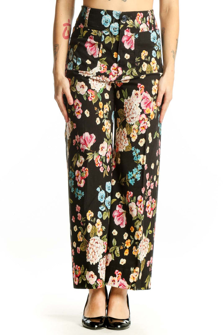 Black floral wide-leg pants with multicolor botanical print, high-waisted fit, front view