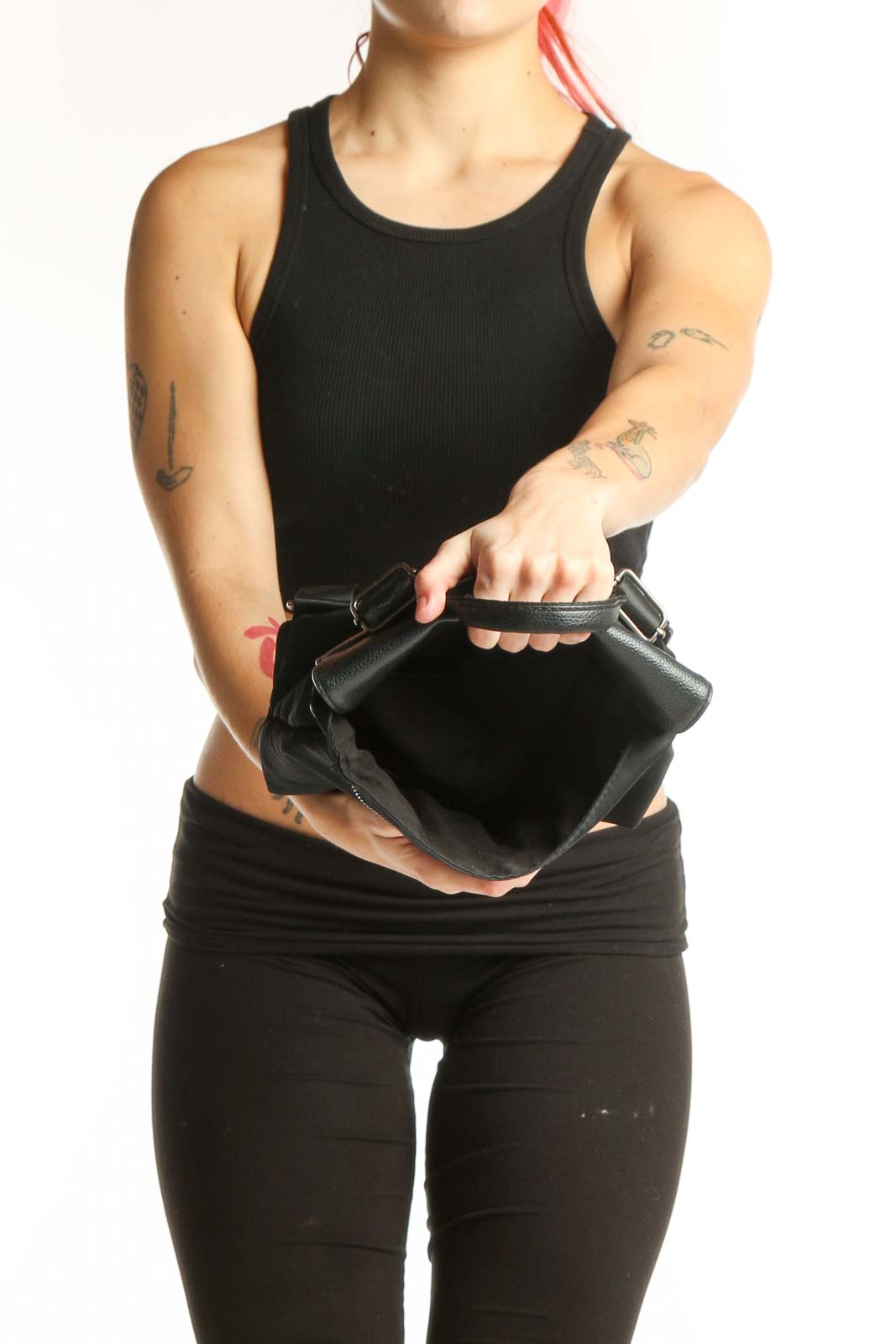 Back view of black leather convertible backpack worn as backpack with padded shoulder straps and metallic flap detail